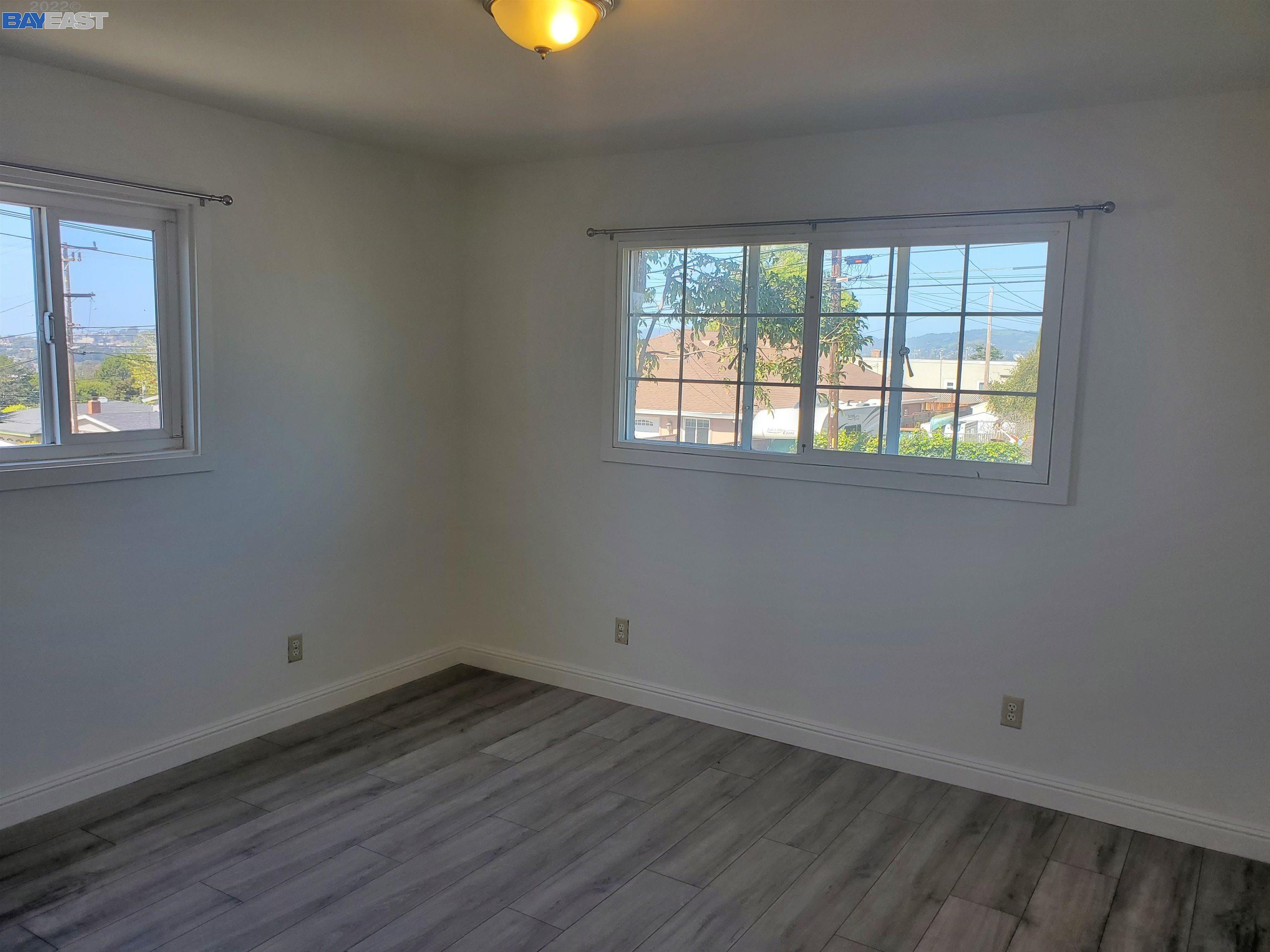 1869 E Street Hayward, CA 94541 - Photo 5 of 22 an empty room with wooden floor and windows