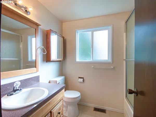 a bathroom with a granite countertop toilet a sink and a mirror