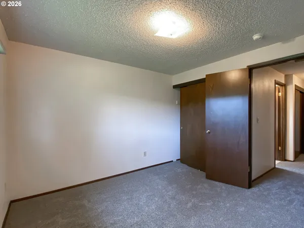 an empty room with closet and mirror