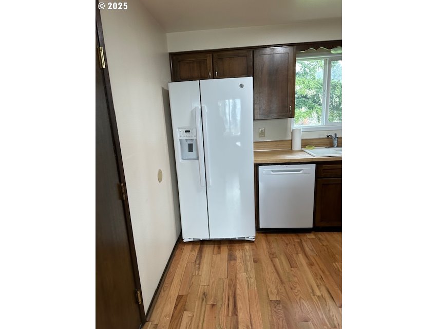 710 Northeast 5th Street Willamina, OR 97396 - Photo 2 of 18 a view of a kitchen with wooden floor and a sink