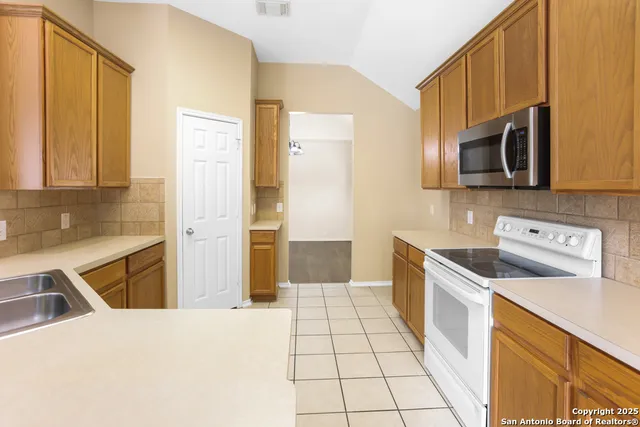 a kitchen with stainless steel appliances a stove top oven and cabinets