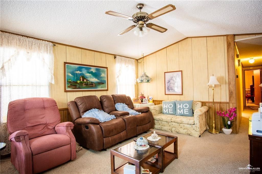 128 Nap Street Mission, TX 78572 - Photo 6 of 14 Living area featuring light-colored wood paneling, textured ceiling, and neutral carpeting