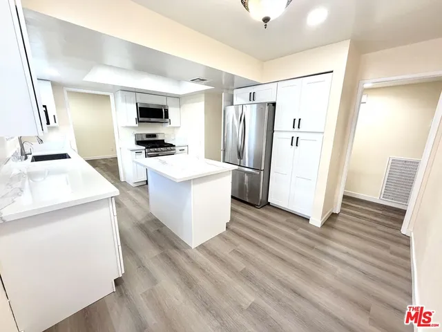 a kitchen with stainless steel appliances a refrigerator and a stove
