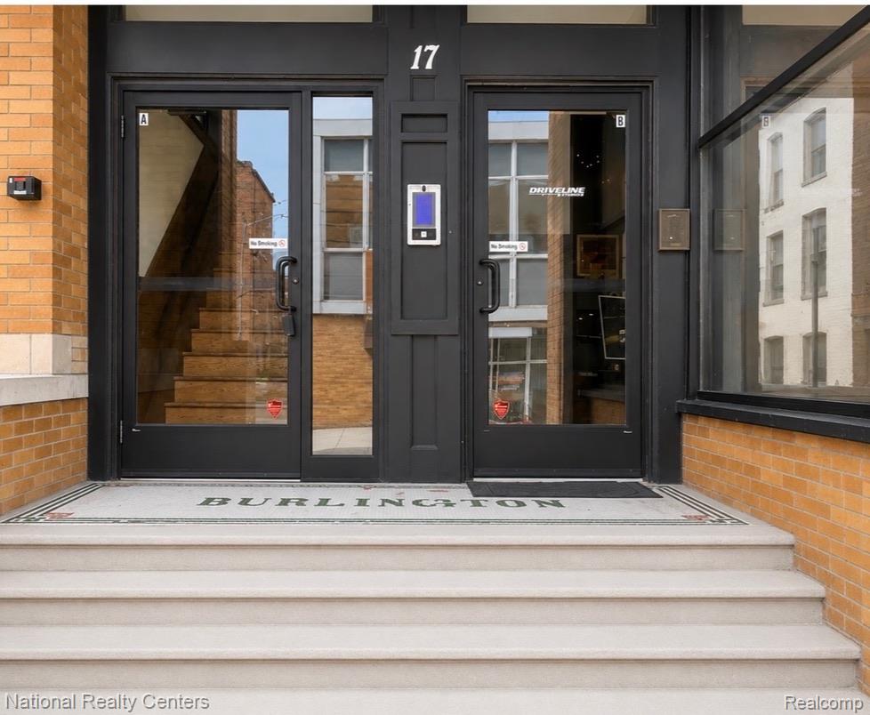 17 West Lawrence Street, Unit 2D Pontiac, MI 48342 - Photo 3 of 12 Entryway featuring concrete steps, a mosaic tile landing, and black-framed glass doors