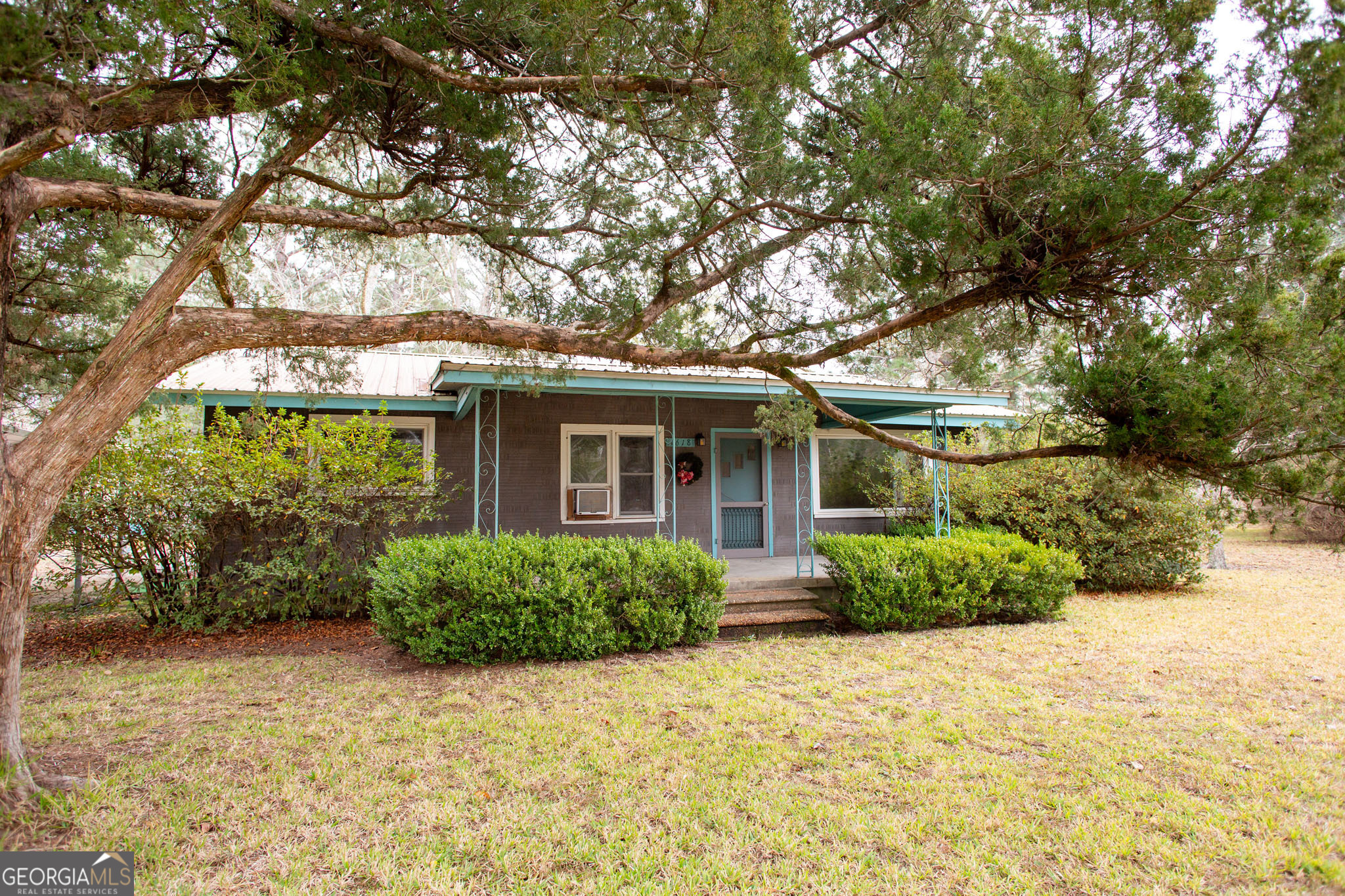 a front view of a house with a yard and potted plants