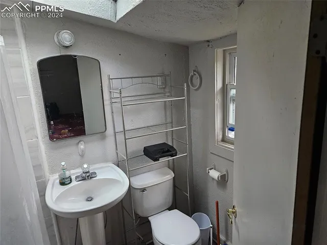 a bathroom with a toilet sink and mirror