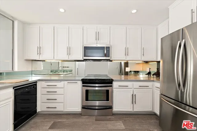 a kitchen with white cabinets and stainless steel appliances