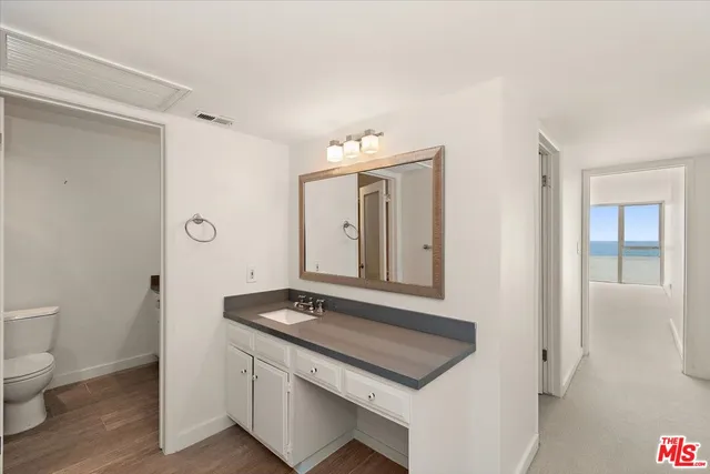 a bathroom with a sink and mirror with toilet