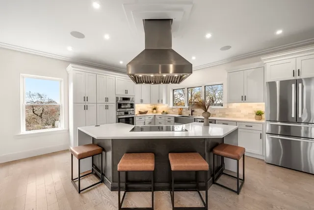 a kitchen with stainless steel appliances kitchen island granite countertop a lot of cabinets and chairs