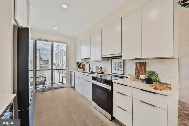 a kitchen with a sink cabinets stainless steel appliances and a window