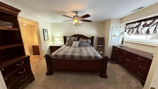 a bedroom with a bed and a flat tv screen on the dresser
