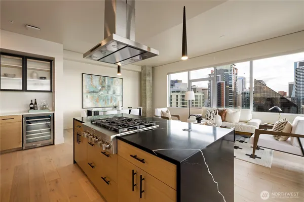 a kitchen with stainless steel appliances granite countertop a stove and a view of living room