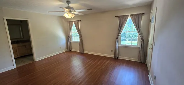 an empty room with wooden floor and mirror