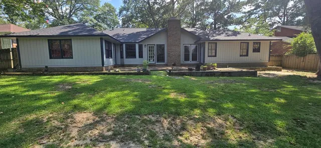 a backyard of a house with yard table and chairs