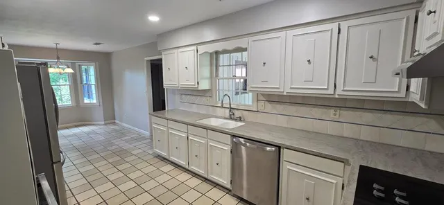 a spacious bathroom with a granite countertop sink and a mirror