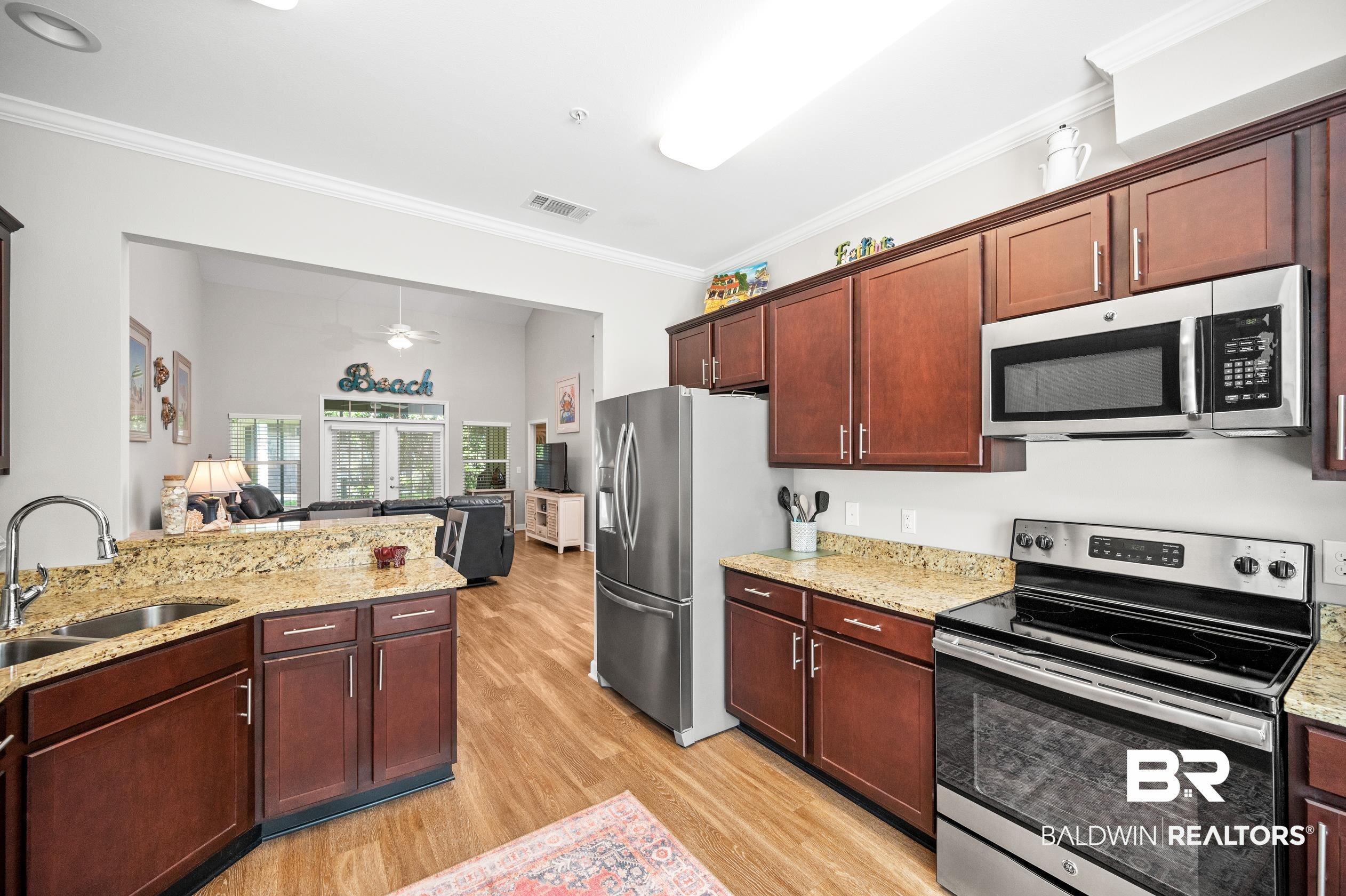 430 West Fort Morgan Road, Unit 1902 Gulf Shores, AL 36542 - Photo 14 of 59 Kitchen with light hardwood / wood-style floors, appliances with stainless steel finishes, light stone countertops, and sink