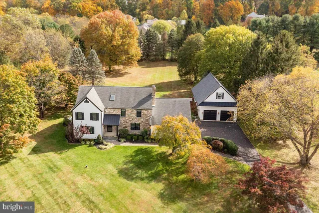 a view of a big house with a big yard and a large tree