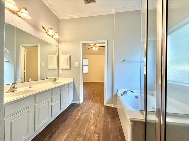 a spacious bathroom with a double vanity sink a mirror and a bathtub