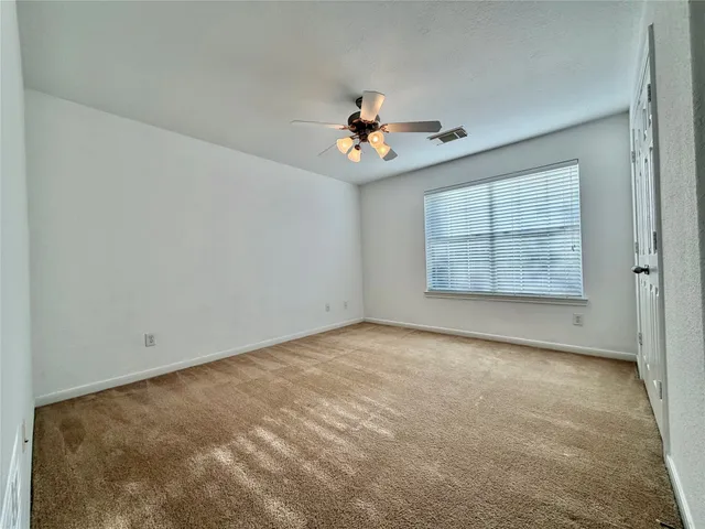 an empty room with windows and cabinet