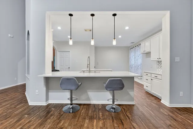 a view of kitchen with center island stainless steel appliances refrigerator stove and wooden floor