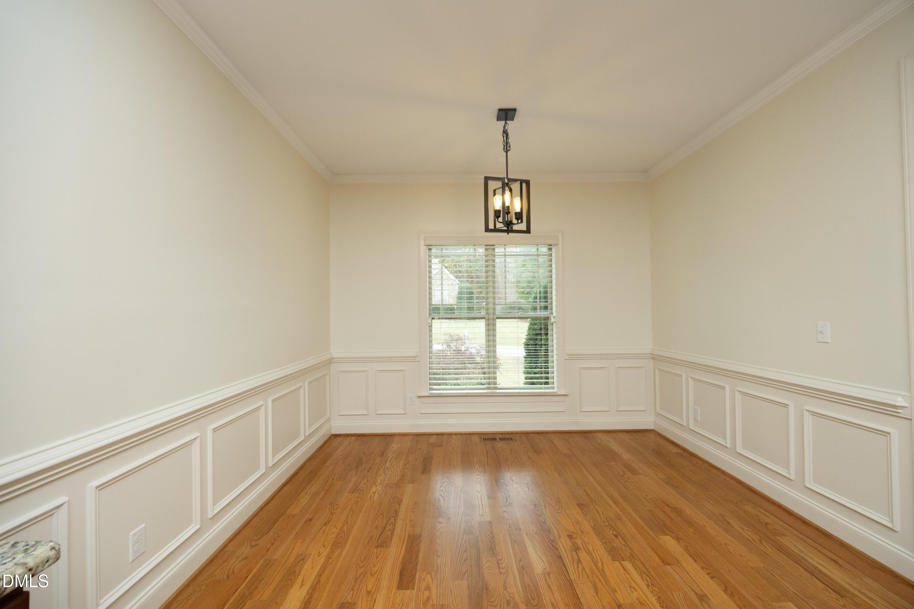 6120 Catandpolly Lane Raleigh, NC 27603 - Photo 12 of 36 a view of an empty room with window and wooden floor