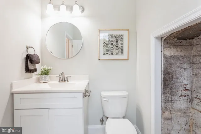 a bathroom with a toilet a sink and a mirror