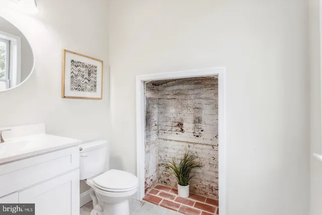 a bathroom with a toilet a sink and a mirror