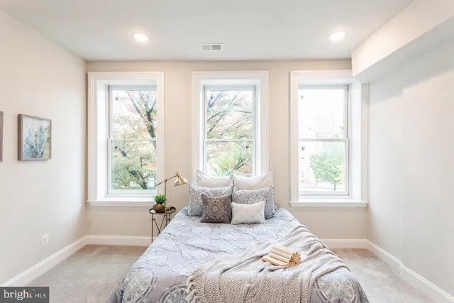 a bedroom with a bed and large window