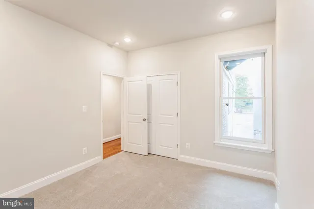 an empty room with windows and closet