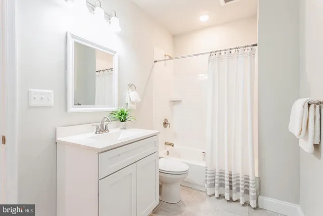 a bathroom with a sink a toilet and shower curtain