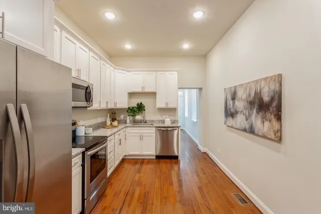 a kitchen with stainless steel appliances granite countertop a refrigerator a stove top oven a sink and dishwasher