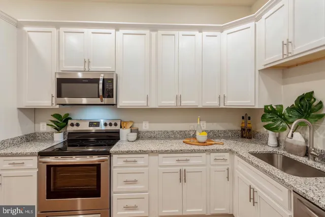 a kitchen with appliances a sink and cabinets