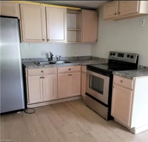 a kitchen with granite countertop cabinets stainless steel appliances and sink
