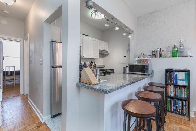 a kitchen with stainless steel appliances granite countertop a sink and a refrigerator