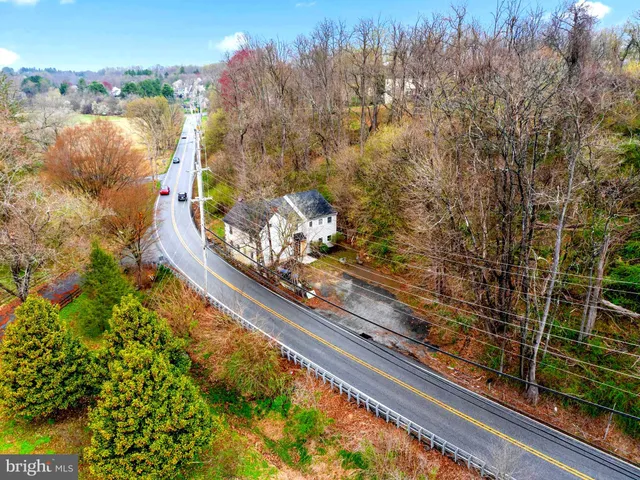 an aerial view of a houses with a yard and lake view