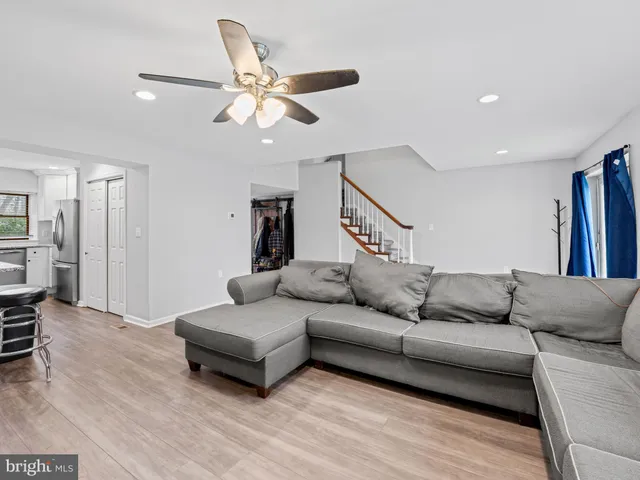 a living room with furniture and a ceiling fan