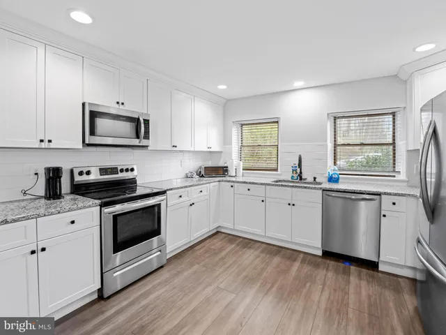 a kitchen with granite countertop white cabinets and white appliances