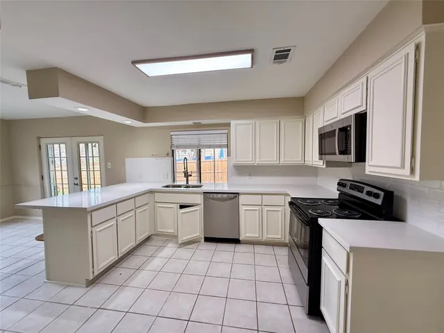 a kitchen with a sink stove and microwave