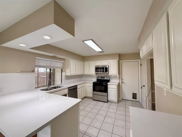 a kitchen with stainless steel appliances a refrigerator sink and stove