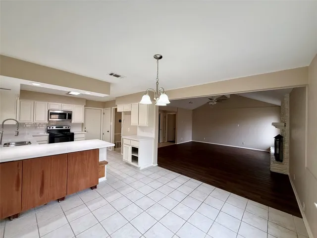 a kitchen with stainless steel appliances kitchen island granite countertop a refrigerator and a sink