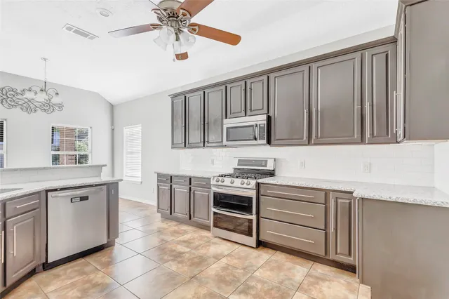 a kitchen with a stove sink and cabinets