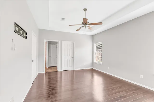 a view of a livingroom with wooden floor and a ceiling fan