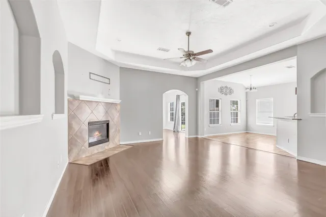 a view of an empty room with window and wooden floor