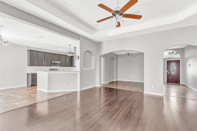 a view of a kitchen with wooden floor and a ceiling fan