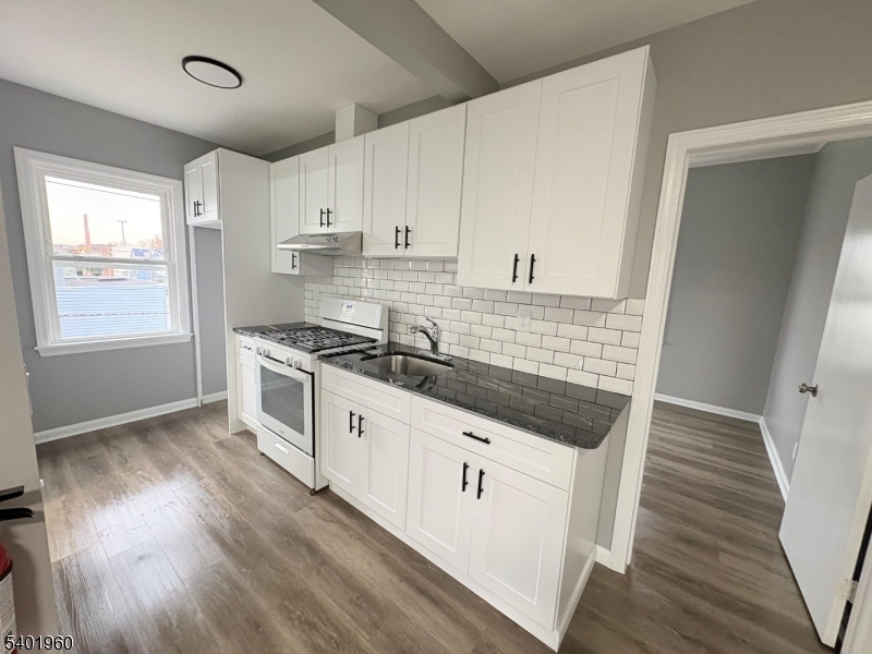 37 Mercer Street, Unit 4 Wallington, NJ 07057 - Photo 2 of 11 a kitchen with granite countertop a sink and cabinets