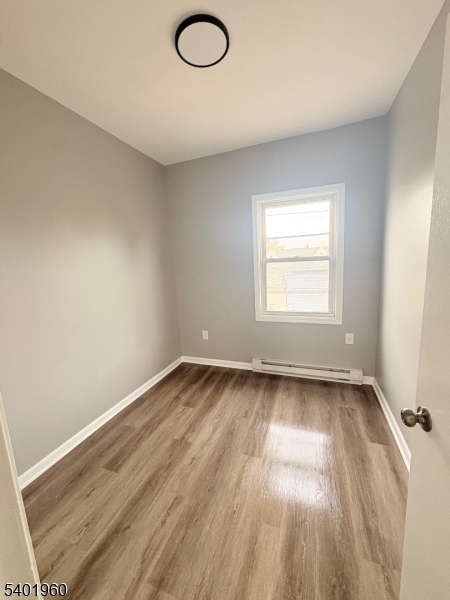 37 Mercer Street, Unit 4 Wallington, NJ 07057 - Photo 7 of 11 an empty room with wooden floor and windows