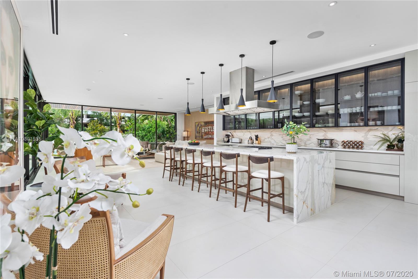 Sunset Islands Miami Beach, FL 33140 - Photo 18 of 72 a dining hall with stainless steel appliances kitchen island granite countertop a table chairs and a living room view