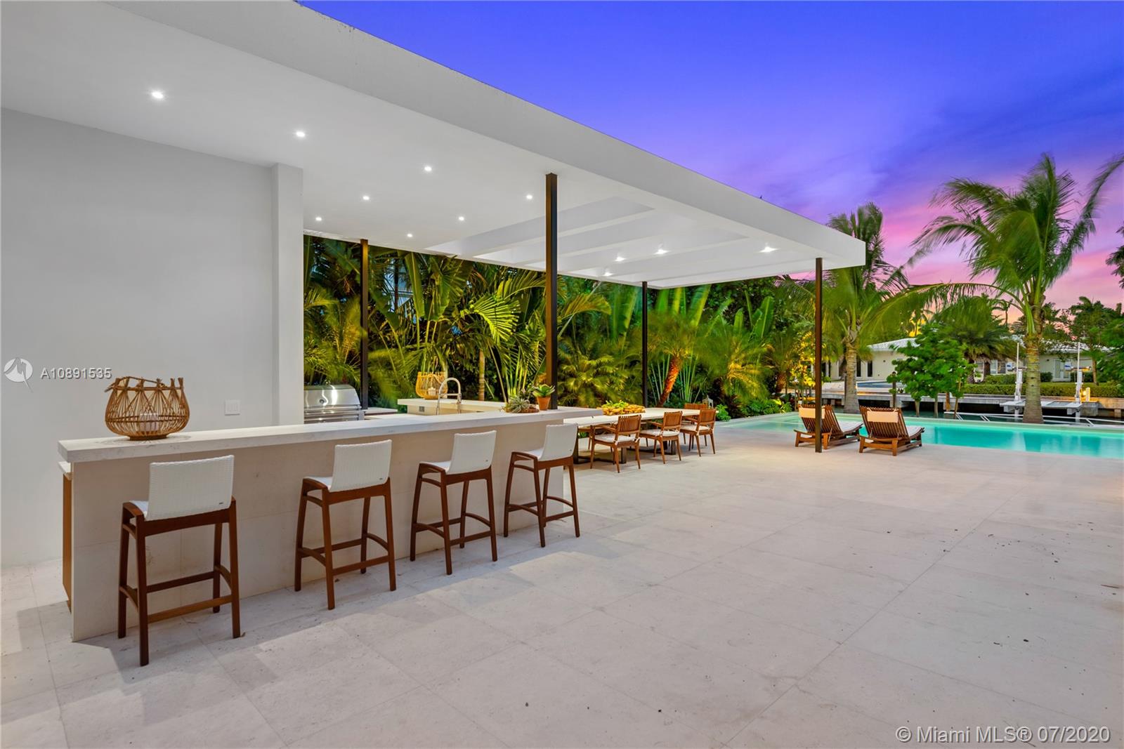 Sunset Islands Miami Beach, FL 33140 - Photo 60 of 72 a view of a patio with table and chairs with wooden fence and plants