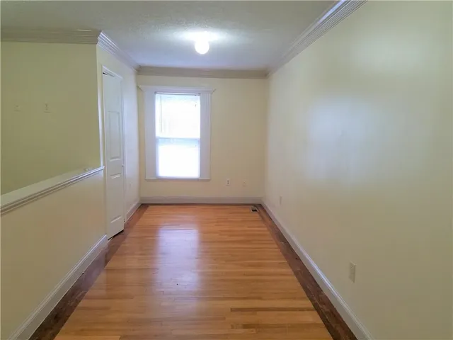 a view of an empty room and wooden floor