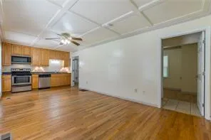 wooden floor in an empty room with a kitchen